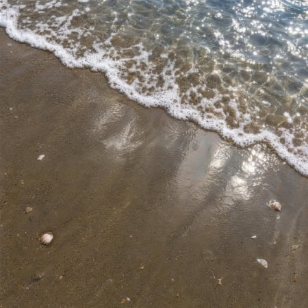 Fotohintergrund: Nasser Sand am Wellensaum
